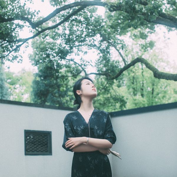 Person meditating in a serene natural setting with soft light.